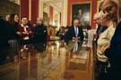 Goście oglądający dary wyeksponowane w gablotach w Sali Rady